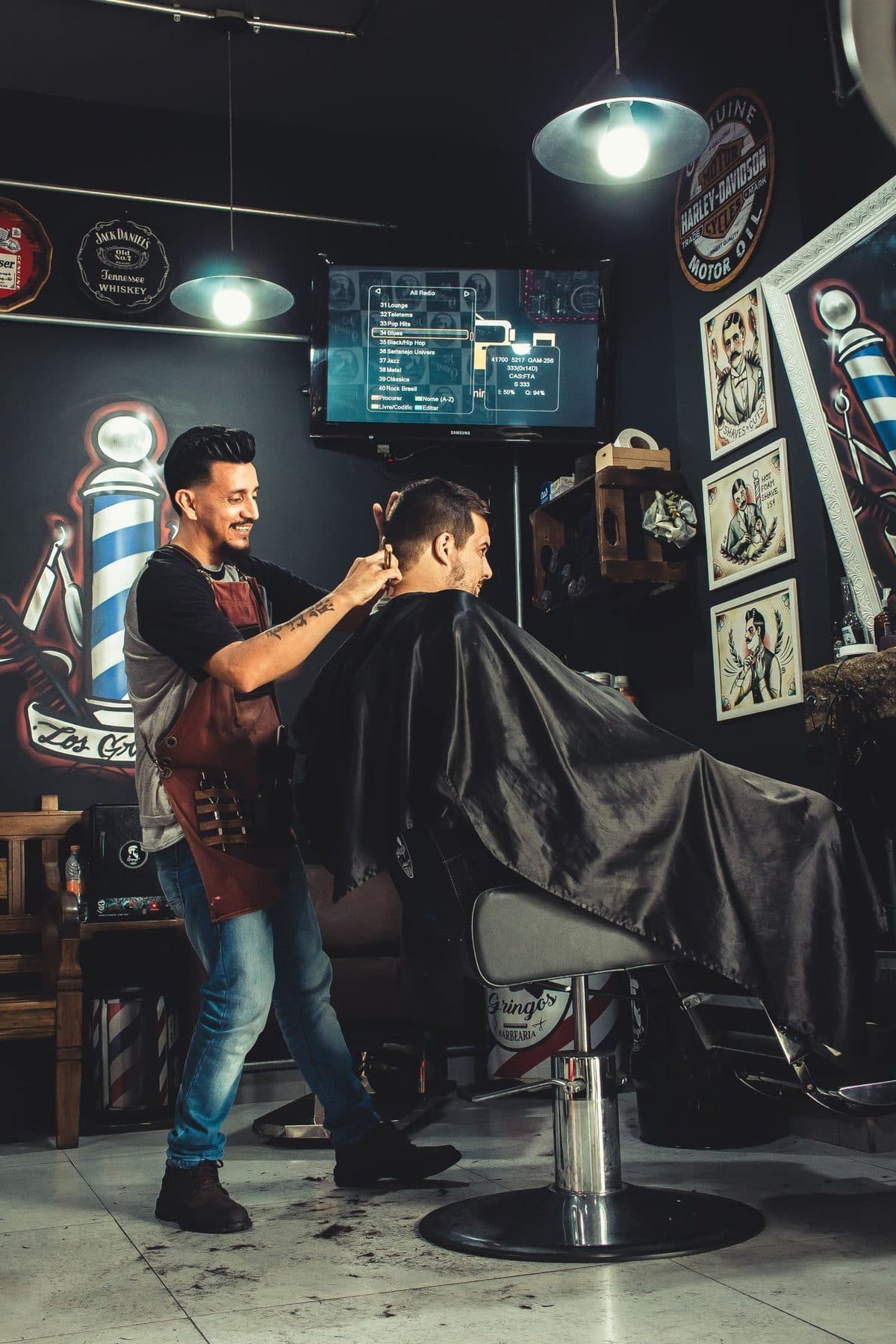 Barbeiro cortando o cabelo de um cliente na barbearia